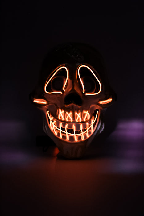 Máscara de calavera con diseño de sonrisa y ojos iluminados con luz led multicolor y detalles dorados