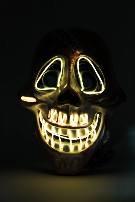 Máscara de calavera con diseño de sonrisa y ojos iluminados con luz led multicolor y detalles dorados