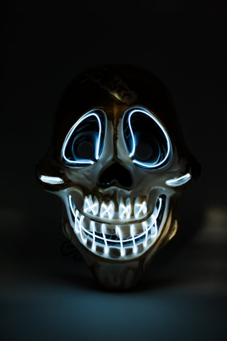 Máscara de calavera con diseño de sonrisa y ojos iluminados con luz led multicolor y detalles dorados